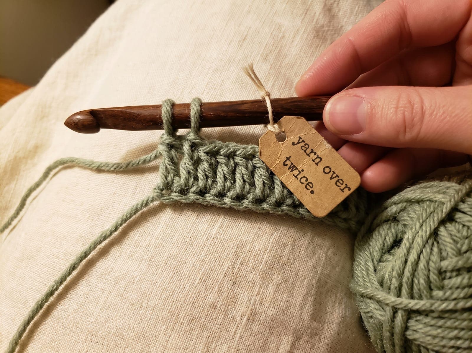 Two yarn overs on the hook before inserting, the first step of treble crochet.