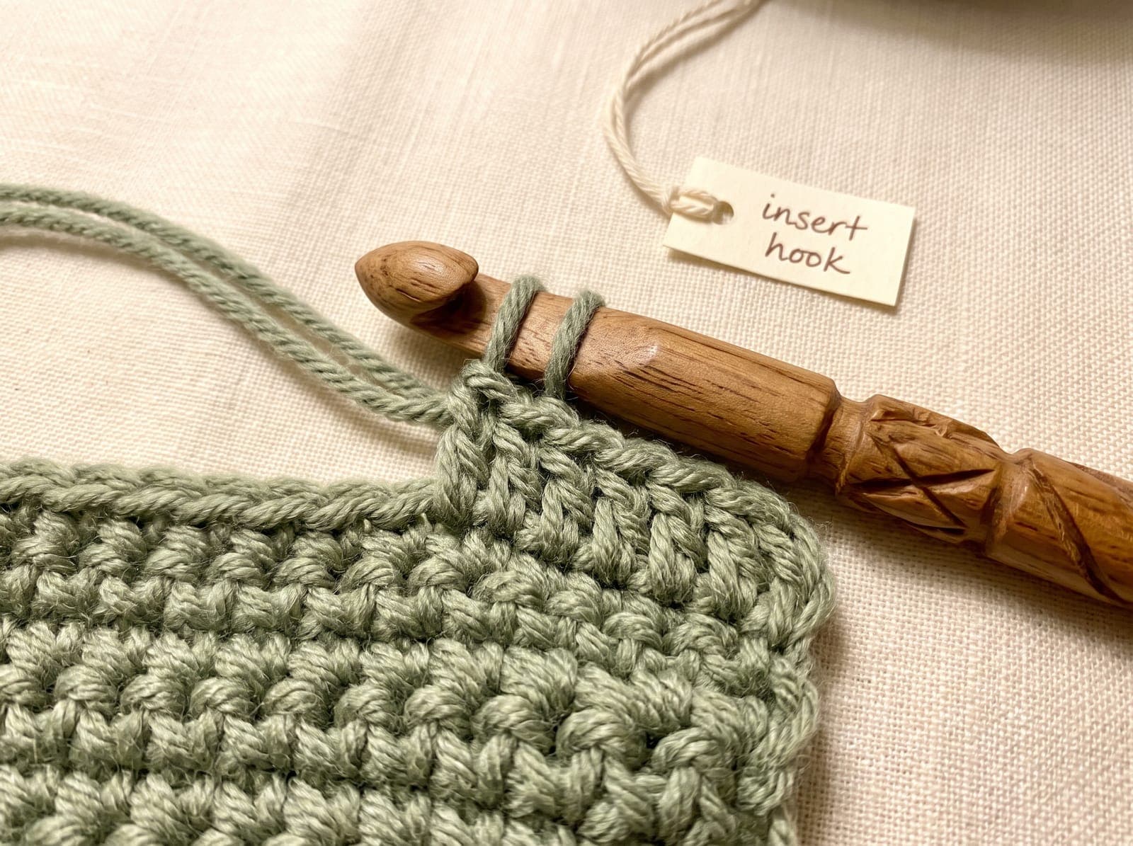 Crochet hook holding two yarn overs inserted under the top two loops of a stitch.