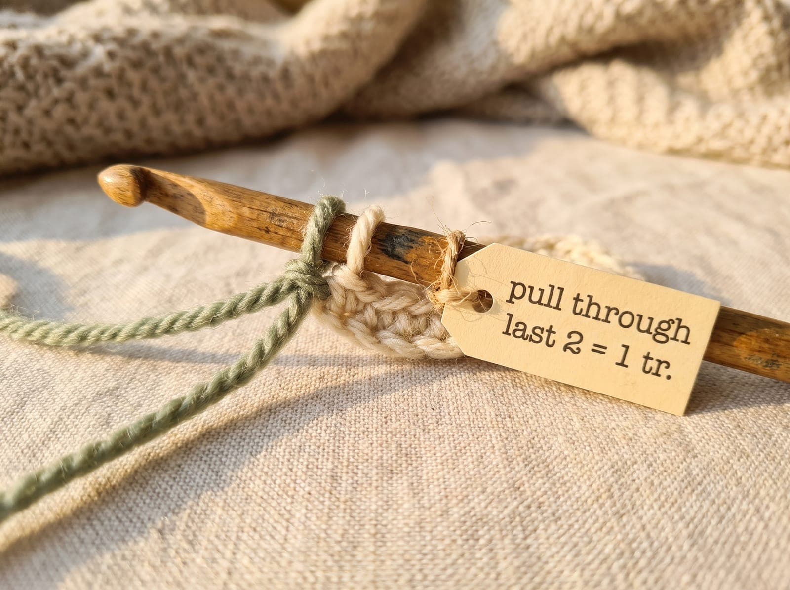 Pulling through the last two loops to complete one treble crochet.