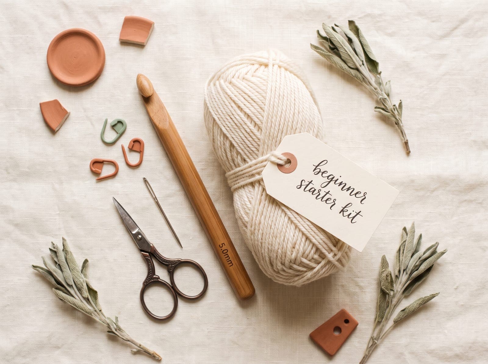 A flat-lay of crochet hooks, notions, and yarn for beginners.