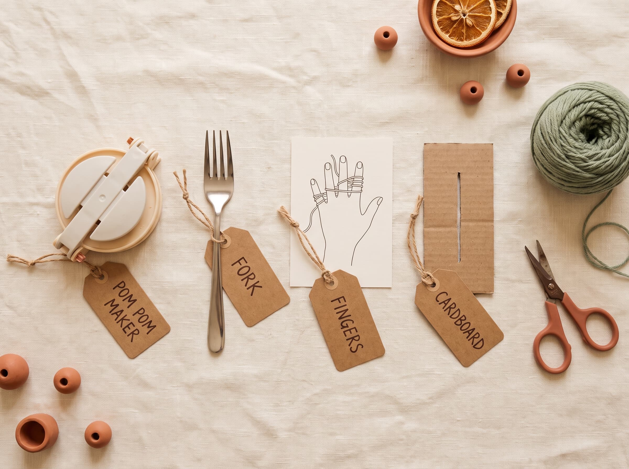 Four pom pom making tools labeled: pom pom maker, fork, fingers, and cardboard, with yarn and scissors.